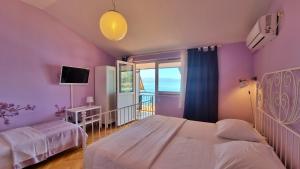 a purple bedroom with two beds and a window at Apartments Soric in Omiš