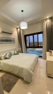 - une chambre avec un grand lit et une grande fenêtre dans l'établissement WASAN LUXURY RESIDENCE HAWANA Salalah, à Salalah