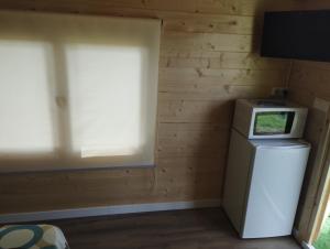 um pequeno quarto com um frigorífico e uma janela em Camping Fraga Balada em Porto do Son