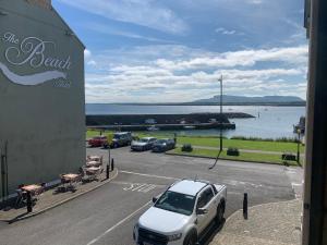 a white car parked in a parking lot next to the water at Harbour View, Mullaghmore, Sligo in Sligo