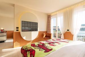 - une chambre avec un lit et une télévision murale dans l'établissement Hotel Grand Koper, à Koper