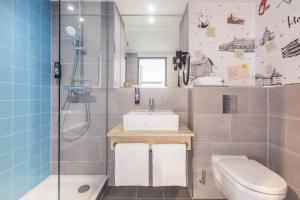 a bathroom with a sink and a toilet and a shower at Holiday Inn - the niu, Yen Hamburg City by IHG in Hamburg
