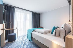 a hotel room with a bed and a large window at Holiday Inn - the niu, Yen Hamburg City by IHG in Hamburg