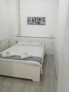 a white bed with two white towels on it at Apartment Teodora in Belgrade