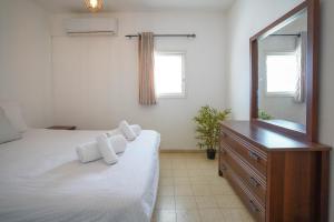 a bedroom with a bed and a dresser and a mirror at דירה יפה ומרווחת במרכז העיר in Eilat