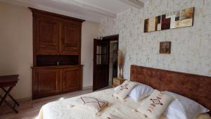 una camera con letto e testiera in legno di La source du Touron a Fons