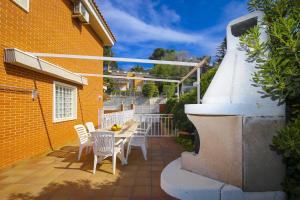 un patio con tavolo, sedie e un edificio di Villa PLUMA Planet Costa Dorada - ONLY FAMILIES a Salou