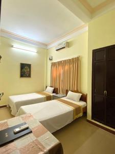 a hotel room with two beds and a window at Bao Minh Hotel in Hue