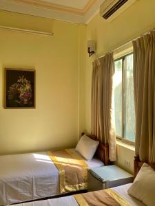 1 dormitorio con 2 camas y ventana en Bao Minh Hotel, en Hue