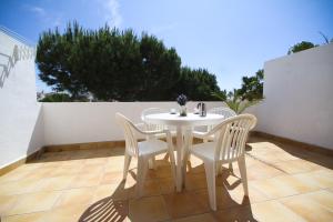 a white table and chairs on a patio at Punta Prima Blau Planet Costa Dorada in La Pineda