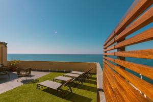 a patio with tables and chairs and the ocean at Taliammari in Cefalù