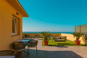 a patio with tables and chairs and a view of the ocean at Taliammari in Cefalù
