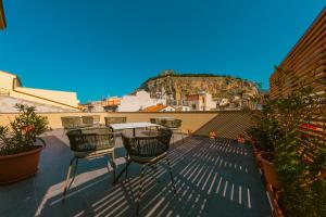 a patio with chairs and a table on a roof at Taliammari in Cefalù