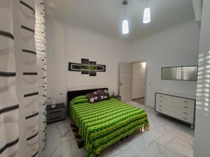 ein Schlafzimmer mit einem Bett mit einer grünen Decke in der Unterkunft Amedeo in Civitanova Marche
