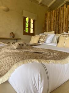 een groot bed met witte lakens en kussens bij The Suite at Garden Village in Kalamaki