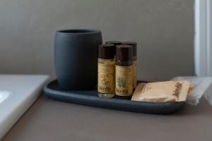 a tray with three bottles of essential oils and a cup at Hotel Villa Cedrino in Dorgali