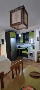 uma cozinha e sala de estar com armários verdes e uma mesa em ALOJAMIENTO YOLANDA CAZORLA em Cazorla