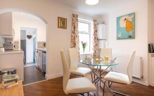 a kitchen and dining room with a glass table and chairs at Bright 3 bedroom townhouse near city centre in Norwich