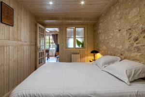 モンベリアルにあるLe 01-GregIMMO-Appart'Hôtelの石壁のベッドルーム1室(大型ベッド1台付) +42枚の写真