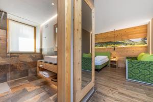 uma casa de banho com chuveiro e uma cama num quarto em Hotel Vittoria - Ricarica l'anima em Dimaro