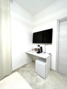 Habitación con escritorio blanco y TV de pantalla plana. en Circeo Boutique Rooms, en San Felice Circeo