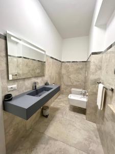 e bagno con lavandino, specchio e vasca. di Circeo Boutique Rooms a San Felice Circeo