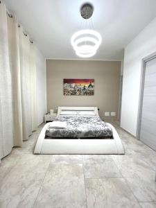 Un dormitorio con una cama blanca y una pintura en la pared en Circeo Boutique Rooms, en San Felice Circeo