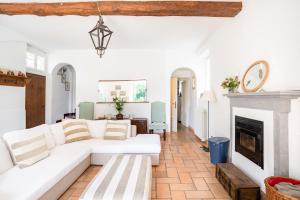 ein Wohnzimmer mit einer weißen Couch und einem Kamin in der Unterkunft Bright APT surrounded by greenery with parking & Shared Pool in Villa Guardia