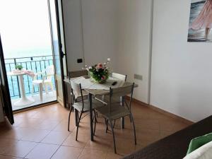 a dining room with a table and chairs and a balcony at La Casa Sulla Scogliera in Cefalù