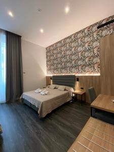 ein Hotelzimmer mit einem Bett und einer Wand in der Unterkunft Hotel Delle Camelie in Florenz