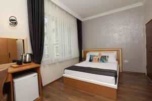 Perazre Hotel في إسطنبول: غرفة نوم صغيرة بها سرير ونافذة