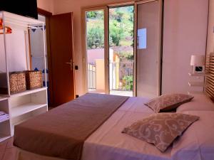 a bedroom with a large bed with a large window at La Casa Sulla Scogliera in Cefalù