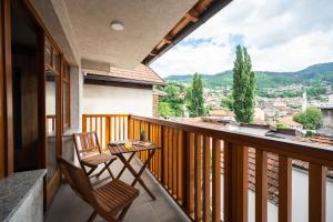 萨拉热窝Duplex Apartment for up to 12 people- Old Town的带两把椅子和一张桌子的阳台