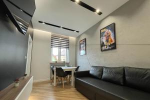 a living room with a black couch and a table at Hill Valley in Kłodzko