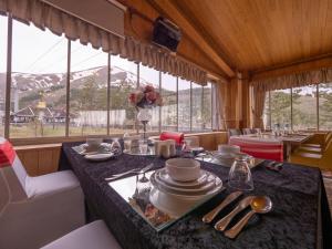 a dining room with a table with dishes on it at Balsoy Mountain Hotel in Erzurum