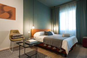 1 dormitorio con 1 cama, 1 silla y 1 mesa en B&B Lorena Suites, en Florencia