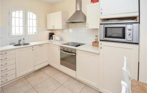 エーグ・モルトにある2 Bedroom Cozy Home In Aigues-Mortesのシンクと電子レンジを備えた白いキッチン