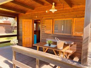 a wooden cabin with a table and a bench on a deck at Le Dune Villaggio in Lido Di Fondi