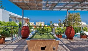 una mesa de ping pong en un patio con macetas en Hotel Koukouras, en Stalós