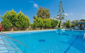 una gran piscina con agua azul y árboles en Hotel Koukouras en Stalós