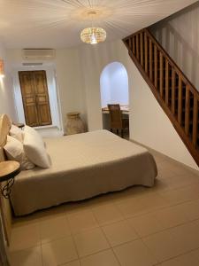 a bedroom with a bed with a staircase and a table at Auberge Coralli in Sartène