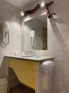 uma casa de banho com um lavatório e um espelho em Auberge Coralli em Sartène
