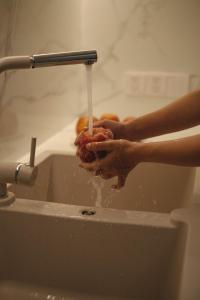 順化的住宿－Nhật Phương Hotel，一个人在水水龙头下面洗手