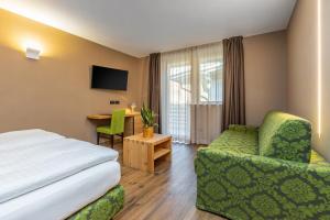 Pokój hotelowy z łóżkiem, krzesłem i biurkiem w obiekcie Hotel Vittoria - Ricarica l'anima w mieście Dimaro