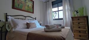 a bedroom with a bed with pillows and a window at ALOJAMIENTO YOLANDA CAZORLA in Cazorla