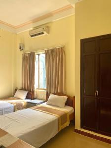 1 dormitorio con 2 camas y ventana en Bao Minh Hotel en Hue