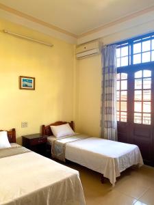 a hotel room with two beds and a window at Bao Minh Hotel in Hue +3 photos