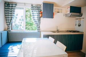 a kitchen with a white table and a window at Camping Wien in Peschiera del Garda