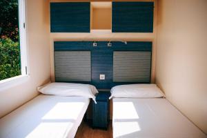 two beds in a small room with a window at Camping Wien in Peschiera del Garda