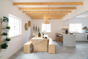 cocina y comedor con paredes blancas y techos de madera en Casa Portus - Turismo Rural, en Faro